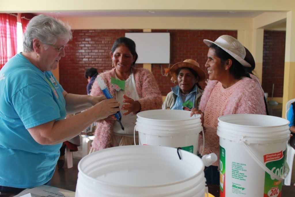 Sister Fran Gorsuch demonstrates the “Water With Blessings” project to Peruvina women